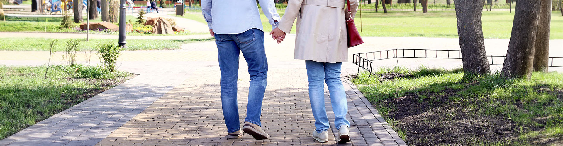 mature couple walking in park on spring day