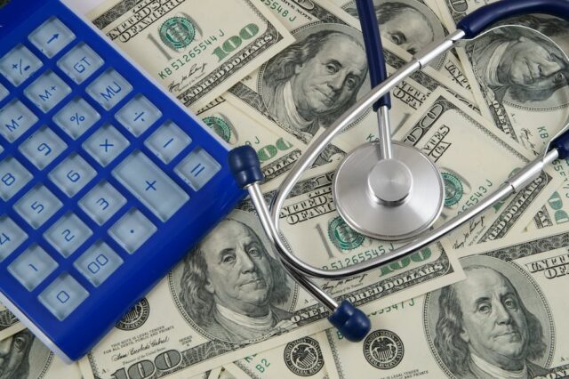 calculator and stethoscope on money