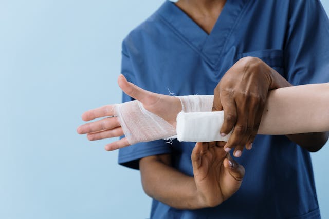 nurse wrapping a patient's hand in gauze