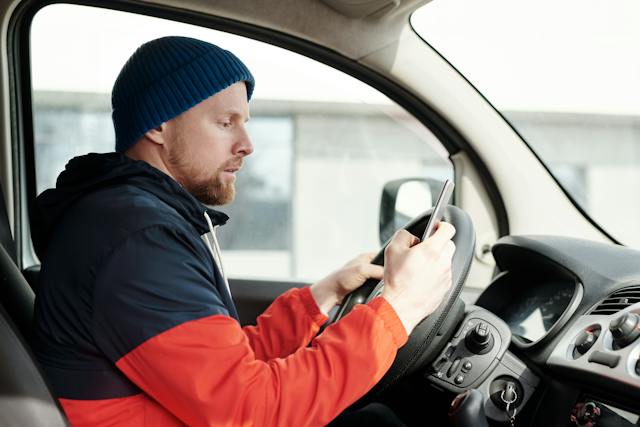 man looking at phone while driving