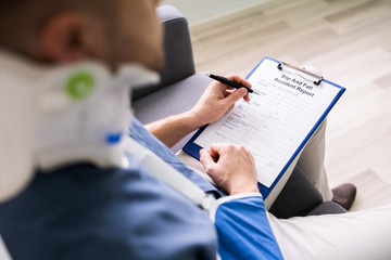 man in neck brace filling out slip and fall accident report